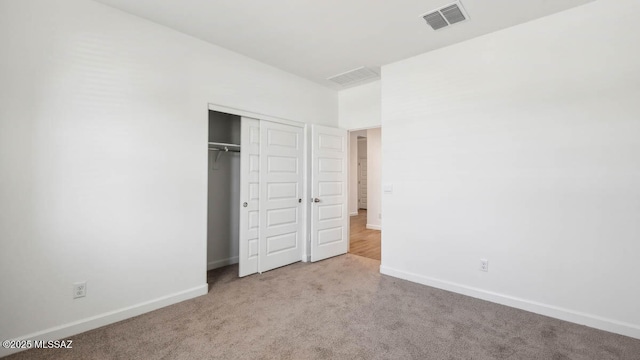 unfurnished bedroom with visible vents, baseboards, carpet floors, and a closet