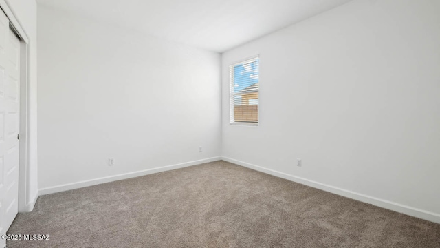 unfurnished bedroom with baseboards, carpet flooring, and a closet