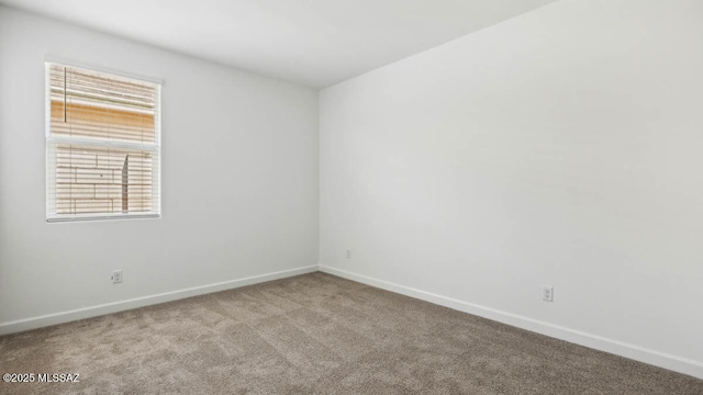 carpeted spare room with baseboards and plenty of natural light