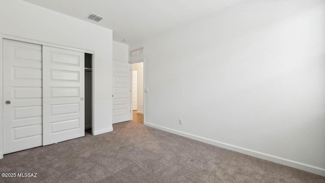 unfurnished bedroom featuring carpet floors, baseboards, a closet, and visible vents