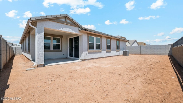 rear view of house with a patio, a fenced backyard, stucco siding, and central air condition unit