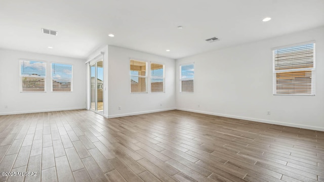 spare room with visible vents, recessed lighting, baseboards, and wood finished floors