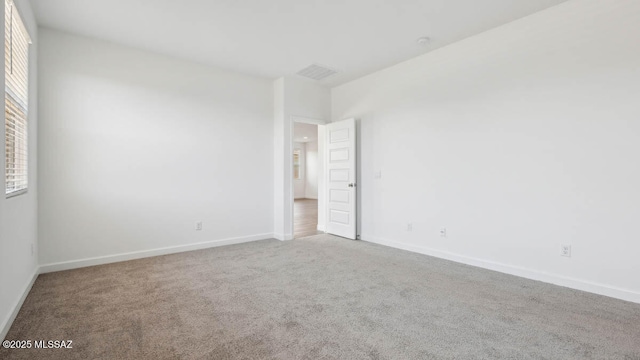 carpeted empty room with baseboards and visible vents