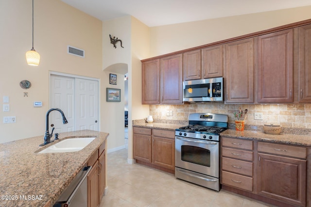 2740 E Ponce Ct, Green Valley, AZ 85614 - kitchen featuring appliances with stainless steel finishes, a sink, backsplash, light stone counters, and a towering ceiling