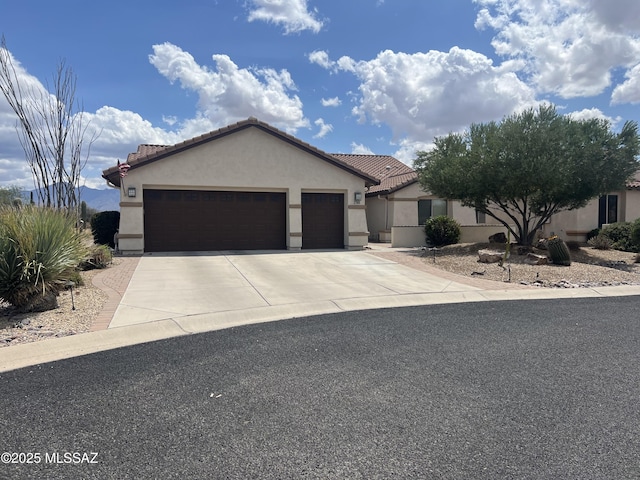single story home featuring concrete driveway, stucco siding, a tiled roof, and a garage