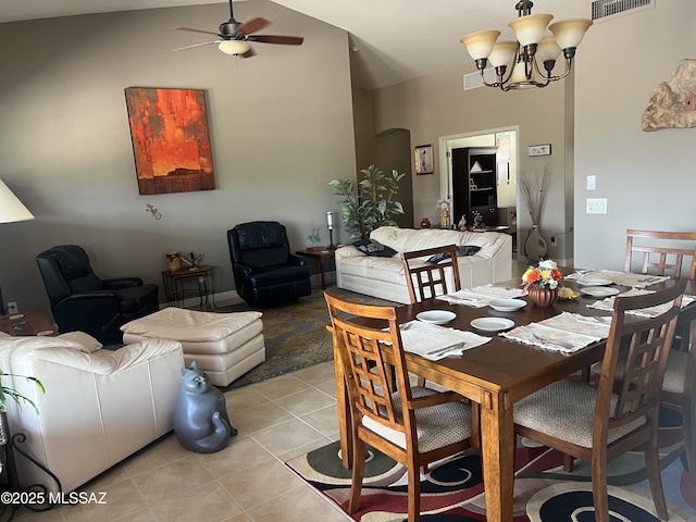 dining room with vaulted ceiling, ceiling fan with notable chandelier, and light tile patterned floors