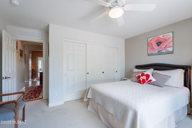 2740 E Ponce Ct, Green Valley, AZ 85614 - bedroom with light carpet, a closet, arched walkways, ceiling fan, and baseboards