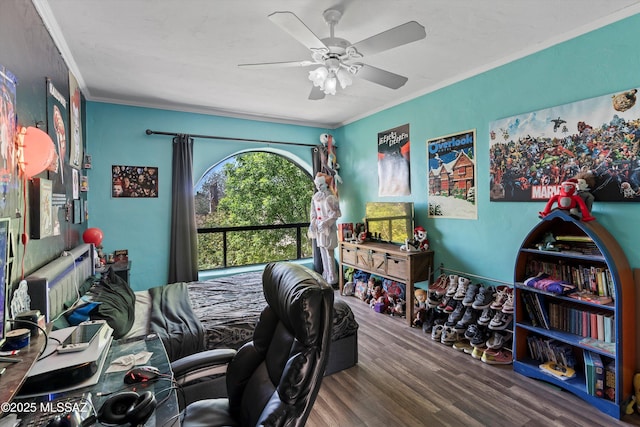bedroom featuring ceiling fan, ornamental molding, and wood finished floors