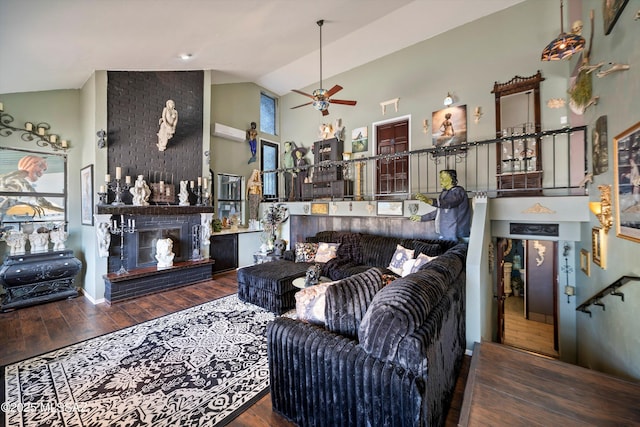 living room with wood finished floors, a fireplace, high vaulted ceiling, plenty of natural light, and a ceiling fan