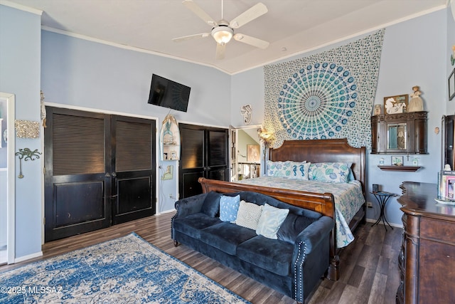 bedroom featuring ceiling fan, baseboards, wood finished floors, lofted ceiling, and ornamental molding
