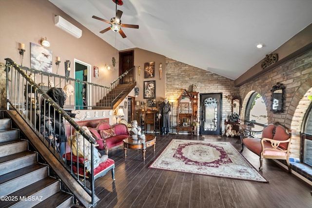 living room featuring wood finished floors, ceiling fan, stairway, plenty of natural light, and a wall unit AC