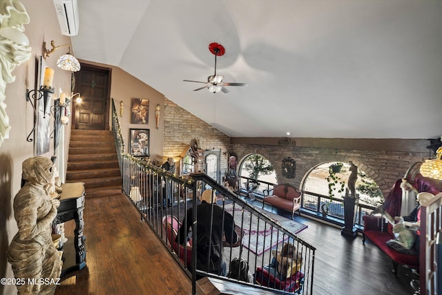 hall featuring vaulted ceiling, wood finished floors, and an upstairs landing