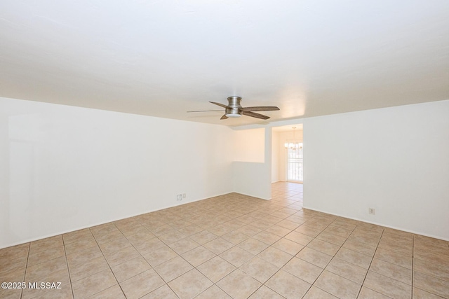 unfurnished room featuring light tile patterned flooring and ceiling fan with notable chandelier