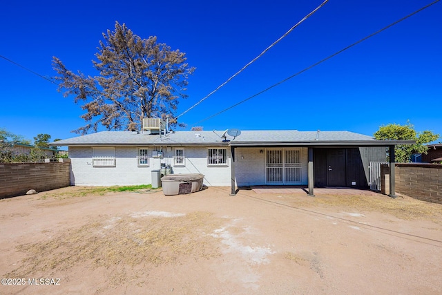 rear view of property with brick siding and fence