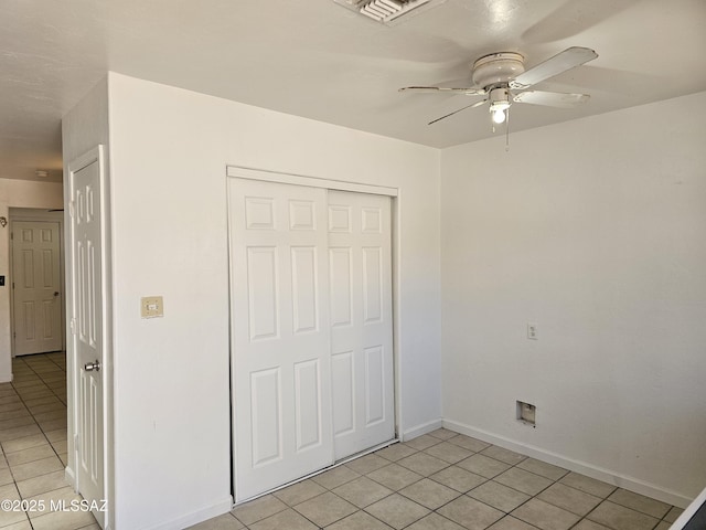 1220-B Circulo Aguilar, Rio Rico, AZ 85648 - unfurnished bedroom featuring light tile patterned flooring, a closet, baseboards, and a ceiling fan