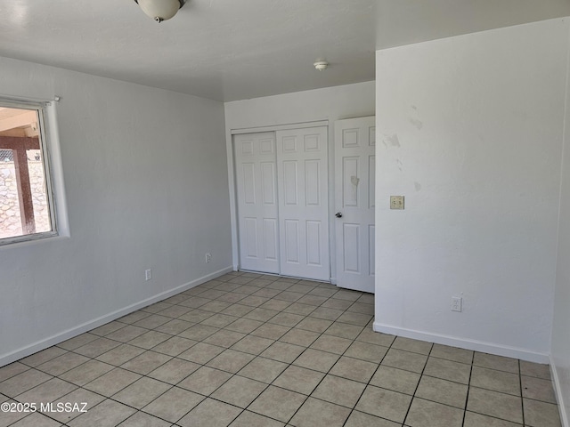 1220-B Circulo Aguilar, Rio Rico, AZ 85648 - unfurnished bedroom with a closet, baseboards, and light tile patterned flooring