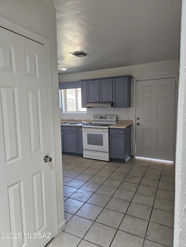 1220-B Circulo Aguilar, Rio Rico, AZ 85648 - kitchen with white electric stove, a sink, gray cabinets, light tile patterned floors, and a textured ceiling