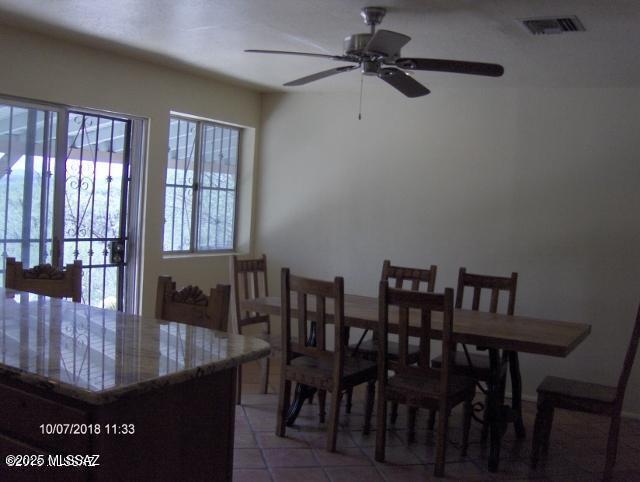 dining space featuring light tile patterned floors, visible vents, and a ceiling fan