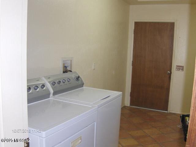 washroom with tile patterned floors, laundry area, and washing machine and dryer