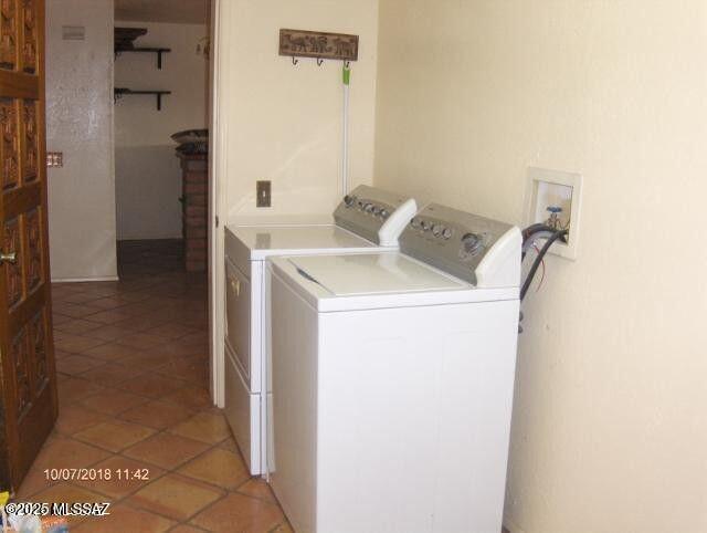 laundry area featuring separate washer and dryer, laundry area, and light tile patterned floors