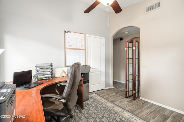 38459 S Bellrock Ct, Tucson, AZ 85739 - office with arched walkways, ceiling fan, wood finished floors, a high ceiling, and baseboards