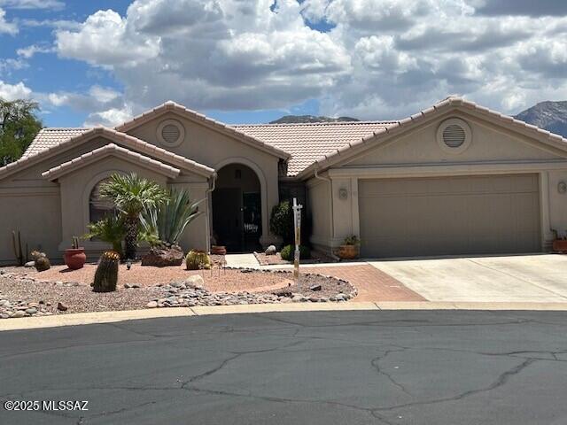 38459 S Bellrock Ct, Tucson, AZ 85739 - mediterranean / spanish home with an attached garage, concrete driveway, a tile roof, and stucco siding