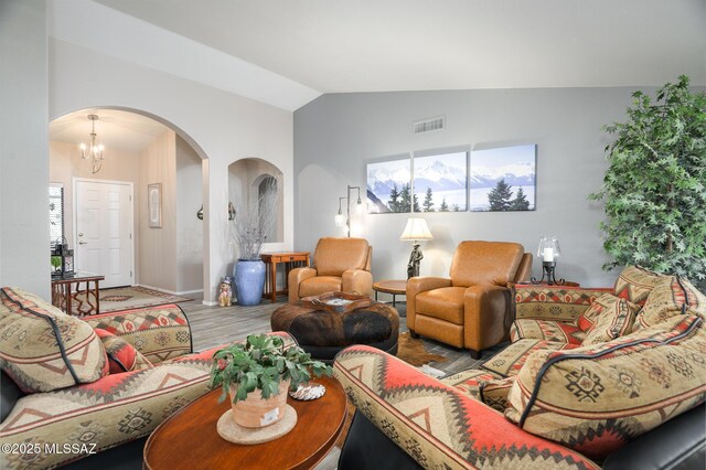 38459 S Bellrock Ct, Tucson, AZ 85739 - living area featuring arched walkways, vaulted ceiling, wood finished floors, a chandelier, and baseboards