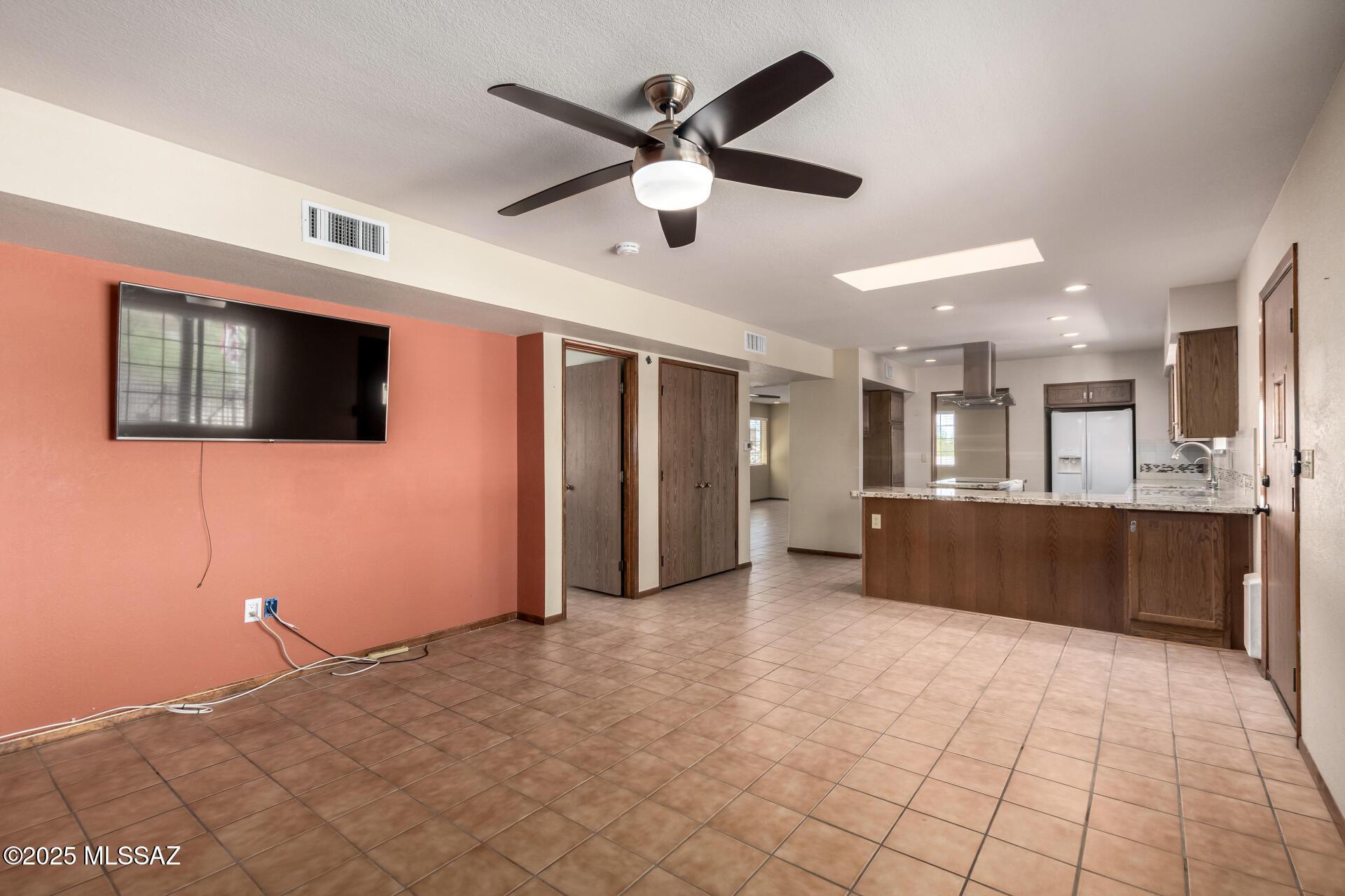 895 W Roller Coaster Rd, Tucson, AZ 85704 - unfurnished living room featuring a ceiling fan and a skylight