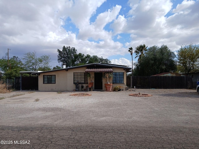 view of front of property with an outdoor fire pit and fence