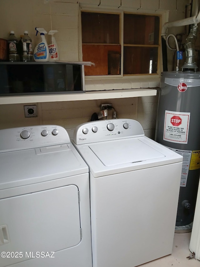 washroom featuring washing machine and dryer, water heater, and laundry area