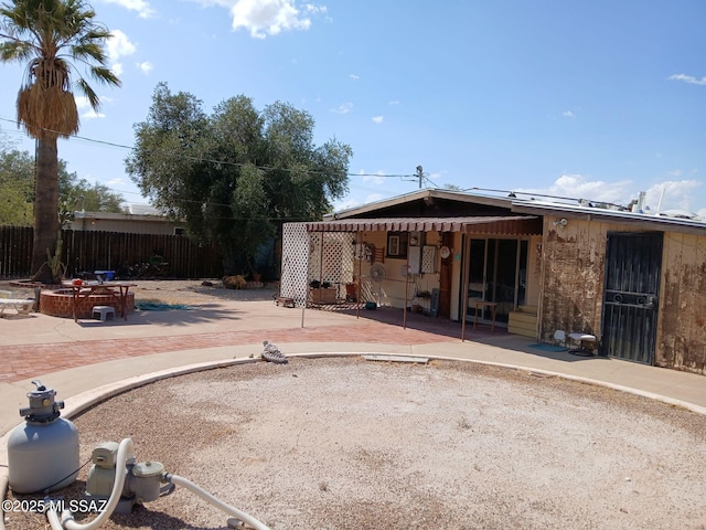 rear view of house featuring a patio area and fence