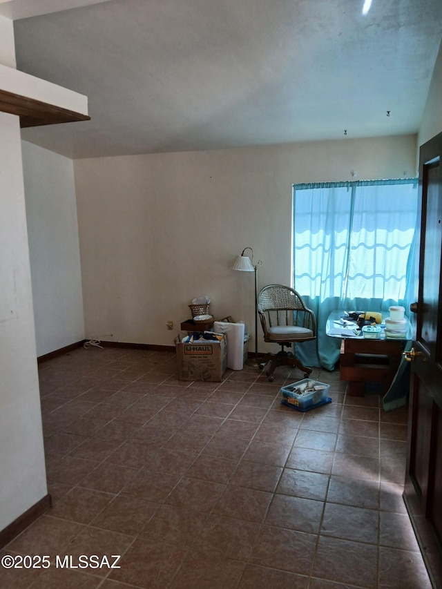 spare room featuring dark tile patterned floors and baseboards