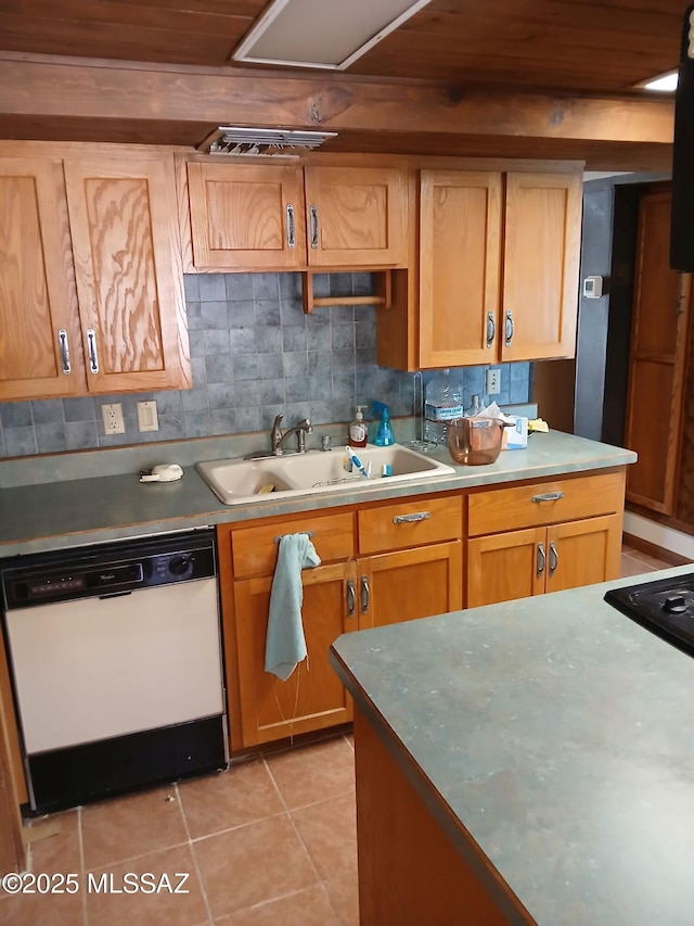 kitchen featuring a sink, dishwasher, decorative backsplash, light countertops, and light tile patterned floors