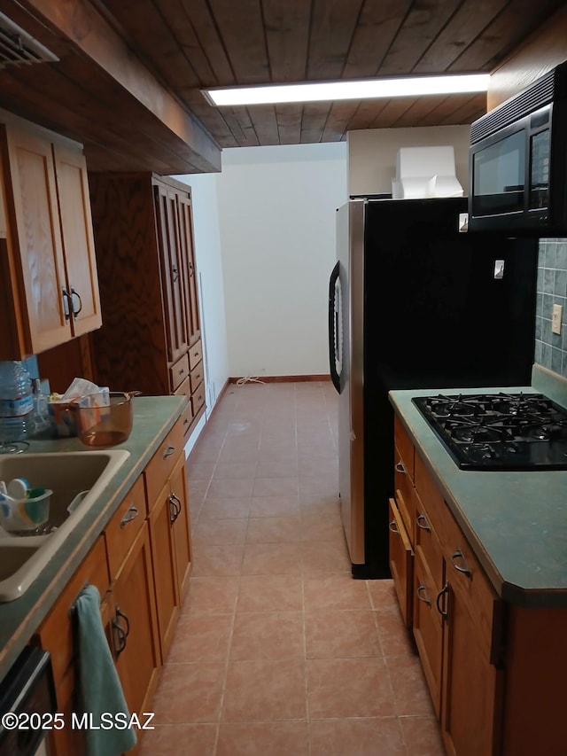 kitchen featuring visible vents, wood ceiling, a sink, brown cabinets, and black appliances