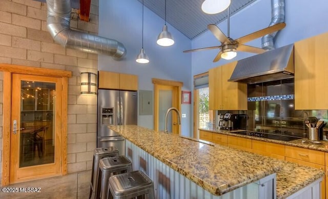 kitchen with a ceiling fan, ventilation hood, high vaulted ceiling, stainless steel refrigerator with ice dispenser, and black electric cooktop