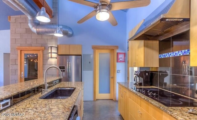 kitchen with a sink, stainless steel refrigerator with ice dispenser, wall chimney range hood, black electric stovetop, and tasteful backsplash