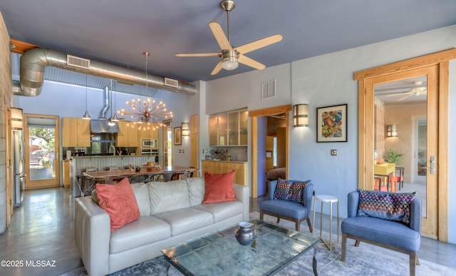 living area with visible vents and ceiling fan with notable chandelier