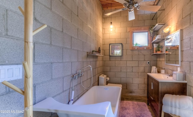 bathroom with ceiling fan, a tub to relax in, and vanity