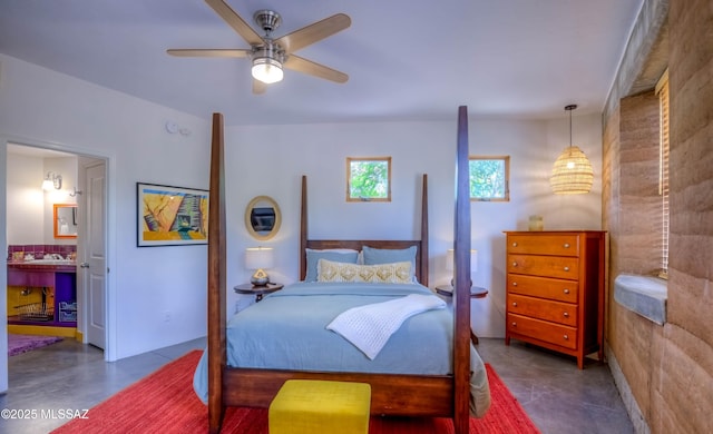 bedroom with ensuite bath, ceiling fan, and concrete flooring