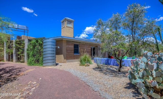 rear view of house featuring a chimney