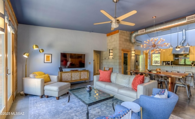 living area featuring ceiling fan with notable chandelier and visible vents