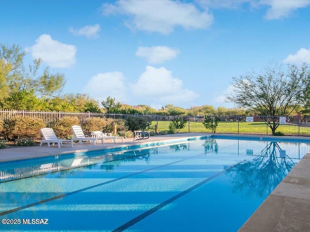 community pool with a patio and fence