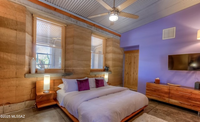 bedroom featuring lofted ceiling, visible vents, and concrete floors
