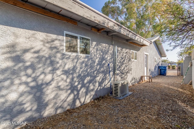 view of property exterior with stucco siding and ac unit
