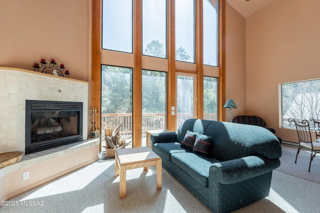 living area with carpet flooring, a fireplace, and a towering ceiling