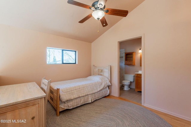 bedroom with a ceiling fan, ensuite bath, light wood-type flooring, and vaulted ceiling
