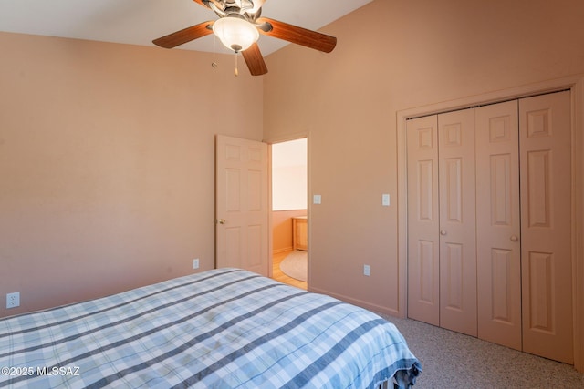 carpeted bedroom with a closet, a ceiling fan, and high vaulted ceiling