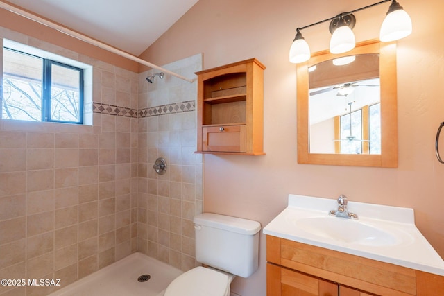 full bathroom featuring vanity, toilet, lofted ceiling, and a tile shower