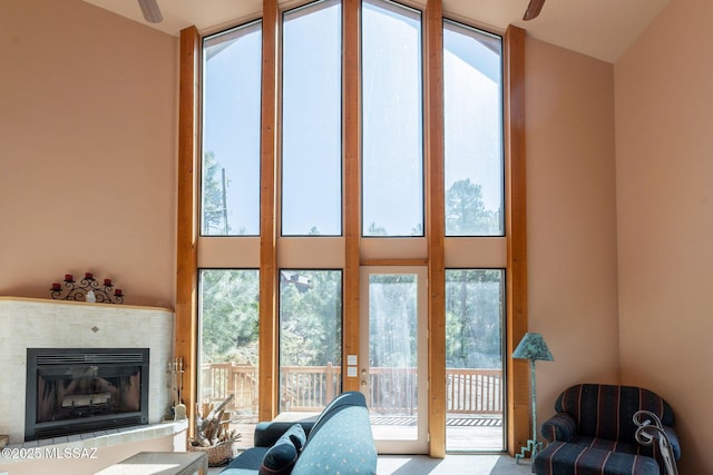 living area featuring carpet, a fireplace, and a high ceiling