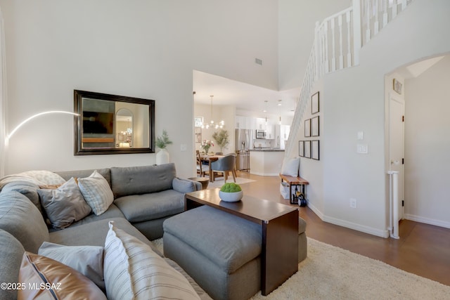 29 W Camino Rancho Viejo, Sahuarita, AZ 85629 - living area featuring arched walkways, baseboards, finished concrete floors, a chandelier, and a high ceiling